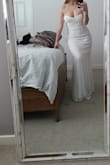 It's a really pretty dress. I ordered the M, I'd usually get a S, but I'm happy I didn't. The top is nice, although it might be too much cleavage for me (43) at my small wedding. That's not the dresse's fault. It is a bit sheer, if I decide to wear it on my day, I'll need to add a slip, I can see about 30% of my light colored thong through the back.
It's a nice dress, probably meant for a smaller chested woman. It will need 2"or higher heels,or a hem job.
:) - Lesley W.