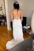 I tried on a few dresses and fell in love with the way this fit!! The pearl and lace were beautiful details. I'll probably need some tape for the bust as I have a small chest, standing it fits perfectly but leaning over, it would gape a tiny bit. Nicely hugs my hips and the open back is really fun. I'm excited to wear this at my upcoming February wedding. Forgive the messy apartment from the at home try on! - Sara L.