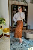 I usually wait to buy things on sale, but I had to have this skirt. So chic, can dress it for fall or spring. It is surprisingly weighty and not flimsy! I was nervous it not fitting my wide hips being that it's a pleather material, but slipped on no issues. Maybe a touch snug around the waist, but not uncomfortable.
I bought a medium. Took pics right out of the box, have not tried getting the creases out yet. - Abigail M.