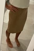 This skirt is cute, but I did order a size up from my normal size. The xs was just a little tight at the waist. The material is a little thin. When you tuck things in, you can see bumps and bulges, but overall it works for work. I don't love the length for me, but I could always get it hemmed if I wanted to put in the effort. - Caroline M.