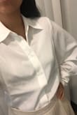 This is not your basic button-up white shirt. It has large and kind of flowy, long sleeves. I love wearing it under sleeveless dresses and tops. It elevates the look in a few seconds. The only downside is that the fabric wrinkles easily. - Ester F.