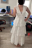 I ordered the dress in both small and medium. The medium ended up fitting me better. It was still a bit loose under my arms, but it fit better around my waist than the small one, as I wanted it to be looser and not feel too tight when I was moving around or sitting down. I already knew from reading other reviews that the dress would have a very low cut, so I had a seamstress add an organza layer and cut the ruffle parts a bit to look more delicate. I just didn't expect it to be so long, but at least it didn't touch the floor. Overall, it was perfect for my civil ceremony! - Stefane H.