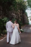 Bought this dress for my wedding in the Bahamas which was on a small budget. I felt so beautiful and absolutely loved it. Even at its low price, I didn't feel like I compromised on my dress at all. The vibe was casual elegance which fit perfectly. The polyester material has a pretty sheen to it that makes it look more expensive than what it is (polyester). I did have a seamstress remove the pockets since you could see them through the dress (Lulus offered a partial refund for my dissatisfaction with the pockets which I appreciated), and add buttons in the back, and hem. Since I'm short I could have added a small train with the hem but I wanted my dress train-less since we were outside and in and out of golf carts all day. My wedding was a super windy day and I was worried about the slit in the dress but it was never an issue! I'll let the pictures speak for themselves. - Katie D.