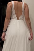 This dress is so beautiful. Great quality, and fits my body so well. The only major alteration needed is the length. I'm 5'5 and I'll have to take off about 3 inches. The bodice is so simple and elegant. The plunge is not very deep and the back is the perfect dip. It does have a bit of a train (1-2 feet behind). The hidden zipper is located down the butt and you can see it a little (pictured) but doesn't bother me. VERY happy with getting my dress online for a reasonable price as opposed to shopping at boutiques all day and spending over $1,000 for a 1-night dress. - Chelsea K.