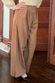 It's made of a type of thin material, but it looks nice. I love the belt because you can easily adjust it to your waist. Perfect length for me so I don't have to wear high heels. - Karla C.