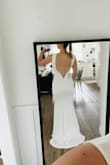 I wasn't sure if this was going to be too plain or how it was going to fit, but it did not disappoint! I knew from the moment I put it on, how well it fit, how the material was (stretchy, comfortable), that this was going to be my dress. 
Due to the high neck, the low back works amazing. The bottom of the back has some bone so it will stay in place/not lose its shape. 
I was more than happy to find a wedding dress under $200! 
FYI: I'm size 6 in lululemon tops/bottoms and between size 27-28 in Levi jeans - Mckenna L.