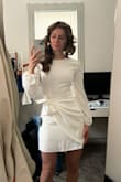 I love this dress! The material is nice; however, it is NOT stretchy. Make sure you get a size that you can comfortably move/sit in. I like that you can tie the knot in different styles. I was worried it may be too short and/or ride up while walking, but it doesn't do either. - Jenna K.