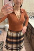 I absolutely love this bodysuit! I was a little weary of how thin the material felt and that between the ribbing was a bit see-through. As soon as I put it on, I knew it was a keeper. It's a beautiful rusty color (not too orange, not dull). The material is soft, smooth, and fits snug without looking too tight. The ribbing and collared v-neck give it a bit of a retro 70's vibe that I love. Lol great with dark jeans and the Mad for Plaid mini skirt from Lulus (pictured) - Coribeth M.
