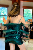 I purchased this dress for a dance show I was in, hoping the material would move with me, and that the dress would be fun but not too flashy for the event. This dress delivered! Not only did it hug all my curves and flatter my shape, but it was so much fun to dance in!! I loved how the fringe swayed with my every step and how the gorgeous emerald sequins peeped through each time the fringe lifted as I spun. The straps are adjustable and the material has a comfortable give to it as well. The fringe is also slightly longer than the lining of the dress itself, making the dress a bit more comfortable in length. Overall a great piece to add to any wardrobe :) - Mariella C.