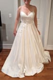I have a month to change my mind lol but I think this is my dress. I've long been drawn to A-line and tulle princess styles but this just looked so much better on my body than any of the dresses with tulle skirts I tried. like to think this dress is the best of all worlds - it has the elegance of satin, the princess effect of a ball gown, a little romantic touch from the appliques... and yes, a touch of cleavage. I'm 5'5", 155 lbs, 32DDD, curves + lots of muscle. The 8 fits great - I think any looser and I'd need to have bra cups put in, tighter and I'd want to size up. Between the boning and big skirt, I think I might want a reception dress to change into after a while but I wouldn't say this is uncomfortable. I had it shortened in the front (not wearing heels) and will have the straps replaced - I don't think they look bad, but given the weight of my bust they dig into my shoulders when I move; I don't want red marks in the photos. (Pictured: the dress out of the bag + after hemming) - Christine F.