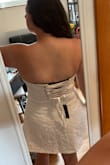 I really like this dress! It is a good length - short but not so short that I feel like I am going to flash anyone. It fits really well and you can tighten the top with the laces in the back to get a perfect fit. The top edge has an elastic-type band around it to help it stay up so it doesn't feel like I'll have to be tugging it all night. - Brittany M.