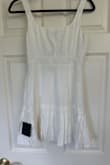 The dress is made from a linen material so it wrinkles and the white is see through. You can see pockets and inner lining. The sizing is also very off. I wear a true S, sometimes XS. Ordered a small in this and cannot get it zipped past my ribcage. I had high hopes for this for my wedding week but sadly, it is a return. - Sarah H.