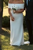 I bought multiple dresses, and this was the winner for our simple ceremony and reception. 
I wore it across my shoulders for our ceremony. I loved that I was able to put the arms/straps down and up depending on the temperature that I was feeling. Most of the night I did one strap because it felt the most comfortable. With both sides on the neckline would ride up and with both out I just didn't feel secure enough being bigger chested.  Felt heavy when it was on the hanger but was not bad once it was on. 
The only downsides of the dress what that I had to get a button added to the back so that I could pin up the train and the material being plain made it hard to find shapewear that did not show. I was able to use some that I purchased at target. - Nita H.