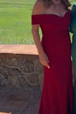 I love this dress so much that I have a black and a reddish one. The material has very little stretch so the breasts stay in place with and without body tape. The material is heavy enough that body imperfections don't show, but can definitely be wore in all seasons. I love the drop sleeve style because it gives the strapless illusion without showing the saggy skin under the arms. This was a big plus for me!!! You can totally dress it up with jewelry and look incredibly elegant or dress it down with a flowery shawl for an outdoor summer event. Very versatile!!!
I wore the red one for my son's summer outdoor wedding, but because I was "The groom's mom" I had the side slit altered to show less legs.
I am wearing the black one for an event this winter and will leave the side slit as is,
If you have a few extra pounds, this dress will elongate your figure and make you look thinner.
I totally recommend this gown. - Monica L.