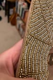 Cheaply made, beading easy to snag on clothing/couches so beware. It also barely fits a phone. I had cut the tag off before coming to the realization I dont care for it and now cannot return. - Jade G.