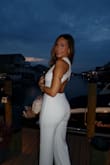 I purchased this jumpsuit for an all white party and it was a HIT. It was super comfy, especially in the hot August weather and it didn't feel super tight or restricting at all. It runs true to size. I personally ordered an XS and it fit perfectly. AMAZING. - Adelina D.