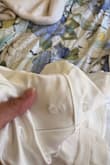 This dress came with one of the buttons that attaches the bow almost falling off and an odd, bad smell. This is what I saw as I had just taken it out of the plastic. I would say that the quality is definitely not worth the price. - Hannah H.