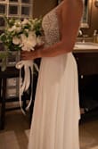 I wanted something simple for my wedding and I wasn't sure about the glitter. However, it turned out perfect! The details of the dress are everything. I didn't use tape or anything else and the dress still stayed in place. I'm not tall at all so I had to have it fixed (just hemmed/cut), but for the rest, everything was perfect! I received a lot of compliments and I felt beautiful! - Estefany R.
