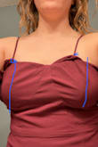 The straps are sewn crooked. There is a bustier top like sewing under the ruffle hem and one strap is sewn about an inch outside from the center of the left boob and the other is sewn one inch inside the center of the right boob. It also runs small, I purchased 4 dresses in my normal size large and the others fit perfectly but this one was tighter around the hips area. - Megan M.