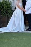 This dress was too long for me at 5'3 so I had to have the length and split adjusted for my height; also had to add a corset back instead of zipper- the top has absolutely no stretch at all so not ideal for a bigger chest- this also helped it not slide around; also asked for a bustle for my reception. After the adjustments it was absolutely what I wanted and well made, the fabric was stiff but it was beautiful in photos and held its shape very well all day and night. It had a glowy effect from the weave of the fabric- I would definitely recommend this dress just be sure to budget for alterations. - Savannah E.