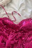 This dress is gorgeous in person! I ordered it for my 40th birthday party, and it is so me! Sparkly, bright pink, fits like a dream, just the right amount of skin showing, and super girly! Its perfect! That being said, I am heartbroken by the condition of the dress. One of the straps is frayed, with strings hanging out all over the place, making it look choppy. The overall quality of the dress seemed really good, but the shedding straps just dont work for me. I dont know if this is reflective of the workmanship or wear and tear from a possible return =( Either way, its not wearable in this condition. UPDATE: decided to get over the fraying straps and wear the dress for my party. A couple of hours into wearing it, my sister called me over to fix a wardrobe malfunction. The boning from the center of the corset was popping out! At the end of the night, the strap ripped off. Super, super disappointed in the quality and end result of this dress=( - Melissa M.
