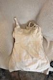 First of all, this is not an ivory dress. This dress is like a light yellow. Second, the dress is so short it is unwearable! This is a size small which fits fine everywhere but fails to cover my butt. If I ordered a size up, I would be drowning, and there is no way to tighten without alterations. Third, the material feels so scratchy and cheap, and does not match the quality in the image. Sad that I will have to pay to return this. - DaKarra D.