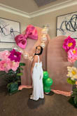 I fell in love with this jumpsuit when I found it on the website and it did not disappoint when I wore it for my shower. The amount of compliments that I received, along with how fun and cute I felt that day, was everything I could've dreamed of and more. I will be honest and say I had to get it altered because of the length (I am 4'10 so most of my clothes have to be hemmed) and the straps were taken in just a bit for more support in the chest to avoid any slips, but otherwise it fit perfectly. The one thing I will share, and this is more my body type than anything, was that every time I went to hug someone, one snap on either side of the bow would let go, but two seconds later we were back in business and good to go. Also, because of my thighs, sometimes when I would walk, the sequins would catch a little bit, but again, it was a second of my life, and I could care less.
I truly felt like this outfit was everything - it was so fun and sparkly and the bow was just the cherry on top. I would Highly Recommend! - Brittany C.