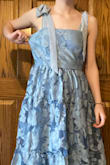 I bought this dress as a bridesmaid for a May wedding. This dress is definitely a team effort, as it's a little difficult to tie the straps yourself. On the back, it has an invisible zipper with a hook and eye, and I was happily surprised with the ease of zipping it up. The dress is a little big for me on the top, but that's mostly because I lack in the bust area lol. I sew, so it's not a big deal for me, but something to consider for my fellow flat chested gals. The inside is lined completely, and I am overall happy with the quality of this dress. The waist gather is a little itchy, but everything else is very comfortable. The bottom of the skirt hits about an inch above my ankle. The bride and I both love the dress, and I can't wait to wear it out! - Avery B.