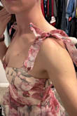 This dress is flirty and fun. The top fits close to your body but it's loose right around the waist and down. The shoulder straps tie into bows and you can choose how tight to make them. I purchased the medium and it fit very well. I couldn't wear any sort of bra with this, but there is some existing support without one. I did end up choosing another dress in its place that was less frilly but it was definitely hard to return this! - Jordan L.