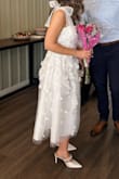 Got soooo many compliments on it at my bridal shower. It definitely fits tight for a Medium, and there is no give/stretch, but wouldn't size up any more - Courtney M.