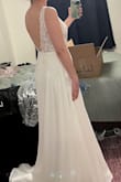 While I did love this dress, I ended up going with something else. It fit perfectly and I'm a medium in everything else lulus, so it seems true to size. I would've needed it hemmed about 3-4 inches. I'm wearing some 2.5 inch heels in the photos, and I'm 5'7. It's got a nice, simple, short train and a flattering draping skirt. The waist has no give, so be careful of that. I also found that the straps on the back would bow out if I pulled my shoulders back. Not sure if some alterations would fix that or if it was because of the low cut. Overall, gorgeous dress and I loved the way it looked, but I went with something else for my wedding dress. - Tricia M.