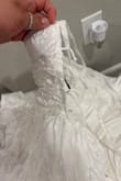 I purchased this dress and it does not look anything like the pictures. On top of that, the hooks where the strings go in completely came off when I tightened the dress. The material of the dress isn't a plain white it's almost iridescent like. Very disappointed - Jasmine M.