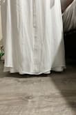 The dress is sewn very unevenly at the bottom. One side hits the floor and the other is perfect length. The back sheer part of the dress comes up above the slip portion of the dress. - Kayla K.
