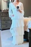 This white tiered dress was exactly what I needed for an all white gala.  It is very flattering with the pleated and tiered ruffles. I have a smaller bust and had no problem without a bra, just silicone pads. I did have to add some double sided dress tape at the front v to offset any gapping while sitting. It did stretch a little in the shoulder area after wearing it. All in all, beautiful dress at a really nice price point. I do recommend. - Erin S.