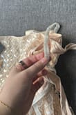 Much more of a pink hue in person. If you are more on the pale side you def need a spray tan lol. Also the beading blends in when photographed rather than sparkling. Lastly, the straps aren't actually attached and are held together with silk ribbon, so they fall super easily. - Maddy R.