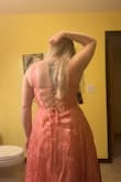 I'm not a fan of how "poofy" the bottom half is, but maybe it's because I'm bigger than the model in the picture and curvier, so that could just be how it sits on my body. The dress is more of a peach or salmon tone rather than the bright pink (I swear it's not just the lighting of my pics). It feels very cheap and honestly looks cheap too. I felt like the lace up back was going to snap the whole time. I do like the corset back because it does hold your boobs for you without needing a bra, but the overall fit is just weird. The fabric feels like plastic, and it's rough. - Clair U.