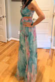 It's flowy, perfect length on me with reasonable heels, and I'm average height. It's got good weight to it. The print and style are lovely. The cutouts hit exactly where I want them to, although I wish the back didn't have an additional cutout- just the sides seem to be flattering enough. I took off one star because I think it's priced too high and the overlay skirt is a fluffy chiffon that can add girth and wimpy spaghetti straps. The picture is me in an xs, but I returned because it was too tight. Waiting for it to go on sale so I can grab the small. Overall spectacular and worth owning. - Marline K.