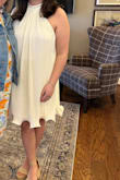 I ordered this dress for my bridal shower and LOVED it! The high neck was snug around my neck after I buttoned it, but that's just because I am not used to having anything remotely fitted on my neck! It just fit like a high neck would! But it was super flowy and had a slight ivory shade to it! I got so many compliments on it, and I can't wait to wear it again! - Leini E.