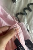 Love the dress. The colour is the perfect pastel pink. The ruffles are adorable. However, the clasp on the back of the dress came broken (missing the hook part). Unfortunately, it cost too much to exchange it, so I will just find a seamstress here to sew one on. Disappointing that it came broken and with some loose strings for the price I paid. But besides that, it's a flattering dress. - Kyleigh K.