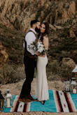 I loved this dress for my courthouse wedding and "wedding" photos. It's pretty stretchy lace/fabric, but the ribbon in the center really has no give. I have a big booty but am a fairly true medium and I didn't have any trouble getting this dress on. The dress looks a little yellow when you first see it, especially if you have it right next to a true white, but don't let that affect you. The dress is beautiful on and photographs perfectly. It is very form fitting, but doesn't hold you in around the waist. So all flaws will show around the tummy. I worked out like crazy to minimize any of those details before our photos. I did get it slightly altered to be perfect for my body just for our photos. With my butt being on the bigger side for this size, the lace was being stretched upward, so the lining layer was noticeably sticking out at the bottom. Also, the fabric was being stretched at the end of the zipper right over my butt which did that zipper curl thing where you could see it poking out just a bit. Others may not have noticed but it bugged me enough to have sewn down. I also had cups added to make the shape of the dress look better. I have shmedium-ish boobs and this dress can definitely hold them, but I like the look of a rounded bra which you can't wear with this dress. It was worth the extra money to feel like every detail was perfect. If you need something quick and/or simple, this is your dress! I wore it unaltered down to the courthouse since it was fine as is. - Erin C.