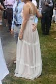 I LOVE this dress. It was my wedding dress for a casual back yard wedding. In typical lulus fashion, the dress is very long so I was able to tailor the front to my height (wearing flats) and keep the longer length in the back for sort of a train (see pic). I also tailored the top to fit better as I have pretty narrow shoulders. The top has lovely embroidering and the bottom has some really simple and soft lace over a light pink/lavender lining. The style of the dress fit my personality so well and had all of the points I wanted in a wedding dress (not white, embroidering, lace over color, and bit bohemian) and I was so happy to have found it. I've tried so many Lulus dresses (probably around 20) and most of them seem to be made of a thick polyester, but occasionally there are thinner polyester that feels more delicate and not so costume dressy and this dress of one of them. The dress is light and airy and was very comfortable for an outdoor wedding in the low 80's. If you are looking for a really lovely dress that will make you feel so pretty, this is the one for you. Highly recommended! - Thuhien N.