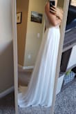 I adore the low back and plunging neckline on this gown! The beading is very intricate in a scalloped pattern over a mesh top with bra cups so it's not too risque. Unfortunately the cups are set a little high or are too small for me, but that's an easy fix the seamstress can handle when I get it hemmed! The length means it will even have a small train after hemming it that she can add a bustle feature to comfortably dance the night away (note I'm wearing heels in these pics so there is even more fabric for a train at my height than it appears in the photo). I love this dress way more than any gown I tried on at a bridal salon and it was a fraction of the cost! - Christine M.