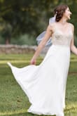 Absolutely love this dress, the only thing I had done to it was hemmed and took off the train. I wanted something with a more contemporary look while still maintaining that bridal elegance (and not looking like a prom dress). I love the scalloping detail that carries throughout the beaded bodice. There are 3 types of "beads" in the bodice; a very simple square cut rhinestone with silver metal outlining, an iridescent "pearl" , and iridescent sequins throughout. The cups are sewn in, but they are not noticeable when you are wearing the dress (at least for me since my skin tone is very similar in shade). The cups are a bit small, so I would take that into consideration for anyone with a C cup or more (for the size 6 I ordered); however, it looks easy enough to have a tailor put different sized cups in. The dress is long and has a slight train to it, so if you don't plan on wearing heels it might need to be hemmed. The fabric is very soft and has a great drape and flow to it and is very comfortable to wear. Literally all night wedding guests, vendors and servers compliment the dress and said it was one of the most wedding dresses they've ever seen. Best part was when I told them it was less than 300 dollars!! So glad I bought this beautiful dress, it was absolutely perfect!! Since I'm posting professional photos, I need to disclose my photographer was Amelya Jayne Photography in North Carolina. - Leah M.