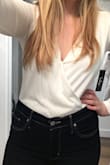 I recommend to size up. I wear a medium normally, but tried the large and it fit well, except was a bit short in torso (and I don't have a long torso).
But oh, how flattering this top is! But man it's tricky- I wore it with mid-rise jeans and the bottom pops out a bit. Also, the top sits well one minute and then opens up revealing my bra the next. So using a pin is necessary for me. - Marianna H.