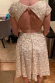 Love this dress! It's a perfect mix of conservative class and sexy skin. The material is nice and heavy, the length hits just below the knee and the skirt is fun and flowy. The kind that twirls when you spin. I was worried about the  the top clasp in the back behind the shoulders as I have very broad shoulders. I was worried it would either be too tight across my back or break when I slouched my shoulders forward. It is neither too tight or break-able. The clasp is actually a thick elastic that goes around a very secure button so if you have to bend over it stretches WITH YOU. I bought this dress for my rehearsal dinner party and I can't wait to wear it all done up! - Amanda H.