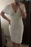 Like other girls on here I ordered this dress for my bridal shower. I wanted something sexy and classy that wasn't too old or too young for my age (27). The material is thick and tight, but not too tight! The right kind of tight that makes you feel secure and allows the white dress to not be see-through. I have a large chest, medium waist and very small hips so I was worried that I wouldn't be able to find my size or that it wouldn't look good on me. I chose Medium and it fits GREAT! It gives me a little bit of hip and the neck doesn't plunge too deep. I think the decolletage is tasteful and the cold shoulders add some fun! It's sexy and classy and still compliments the not too tiny waisted girls! Ps: it does wrinkle easily. - Kenna M.