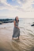 I got this dress to wear for a family photoshoot in Maui. It felt amazing and I loved how it looked in pictures. I ended up having it hemmed for length so I could wear it barefoot, and I had the seamstress also sew the front together just a little so I wouldn't have to worry about it gaping in the pictures. I think it would have been find without, but it made me more confident while taking photos. Overall I recommend this dress - I felt great in it. I like that there are different ways to tie it, and I think I would experiment with that next time. My bust is on the small side, so I bought a backless stick-on bra that worked well. The dress with that bra made me look busty! - Ramah R.