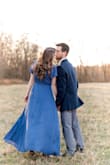 This dress is a beautiful color and fun to wear. It was the perfect height with short heels on and did not need hemmed for my height. Wore it for my engagement pictures and love how they turned out. It is a true wrap dress but had a button at the V neck to keep it closed. It is a thinner material so I would wear it more for warm weather. - Emily S.