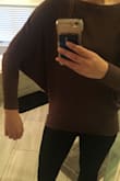 It's flattering because it's very fitted in the lower arms and then at the bottom. It's not as long on me as in the photo but I have a long torso. I can wear it with black pants for work or with jeans on the weekend! It's a good staple to have! - Victoria A.