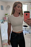 I'm going to exchange mine for a medium and in black. I'm wearing a nude bra in the pic and you can see it, the tag on the shirt, everything, BUT the material feels great. Also of note, the seam of the shoulders is set in a little bit. My finger is where the edge of my shoulder is. - Meredith E.